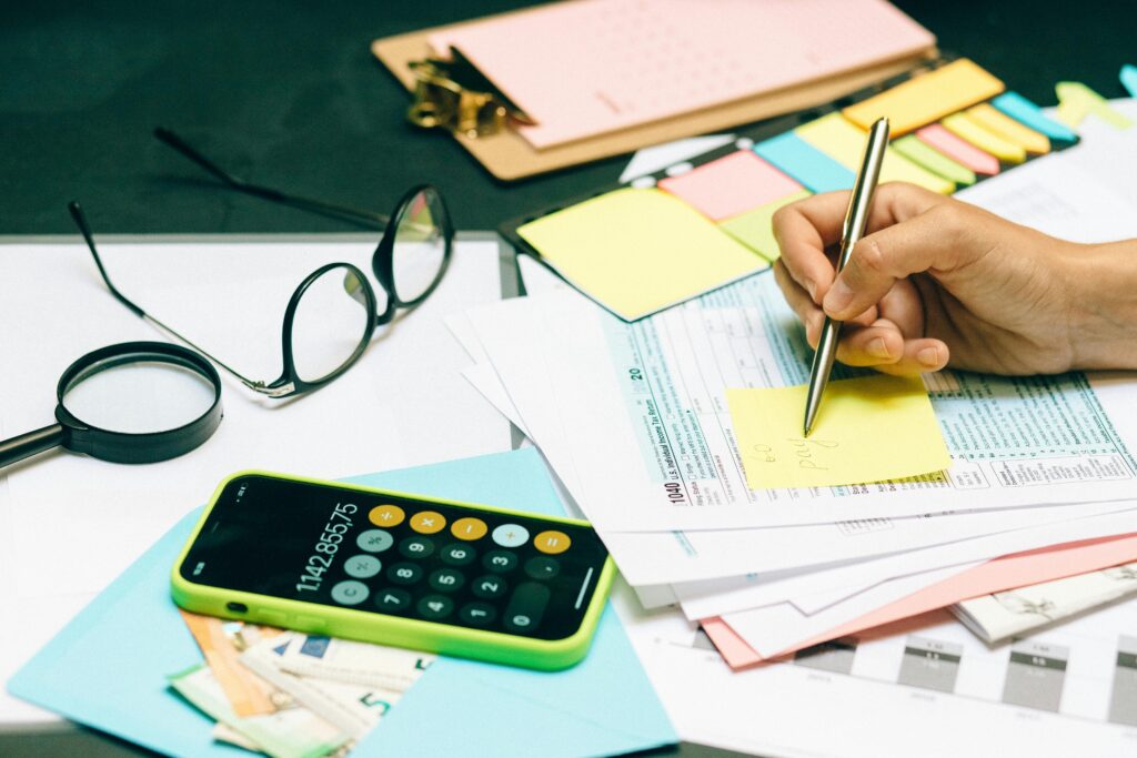 Close-up of an office desk with a calculator, glasses, and documents for financial planning.